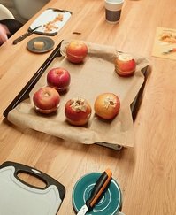 Vorbereitete Bratäpfel auf einem mit Backpapier ausgelegten Backblech 